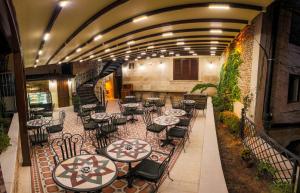 a restaurant with tables and chairs and a staircase at Sam Franss Boutique Otel in Hatay