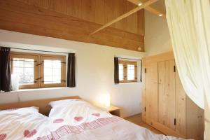 a bedroom with a bed and two windows at Ansitz Parstorfer in Chieming