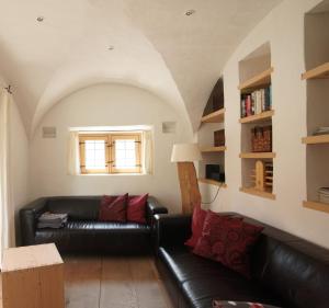 sala de estar con sofá de cuero negro y ventana en Ansitz Parstorfer, en Chieming