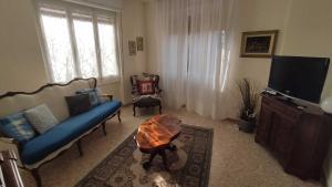 een woonkamer met een blauwe bank en een tv bij Brezza di Lago in Salò