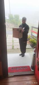 a person standing outside a door holding a box at La Tana dello Scoiattolo - Adults Only in Murazzano +104 photos
