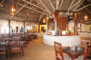 a dining room with tables and chairs in a restaurant at Veraclub Zanzibar Village in Kiwengwa
