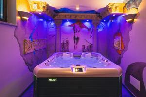 uma banheira de hidromassagem num quarto com iluminação roxa em TatrApart em Zakopane