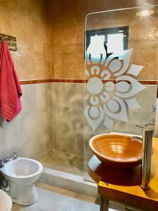 y baño con aseo, ducha y lavamanos. en Toca Madera en Merlo