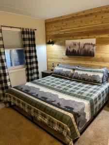 a bedroom with a bed with a wooden wall at A Guest Favorite Your Smokey Mountain Escape that is fully stocked with all the comforts of home in Gatlinburg