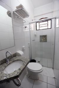 La salle de bains est pourvue d'un lavabo et de toilettes. dans l'établissement Hotel King, à Sao Jose do Rio Preto