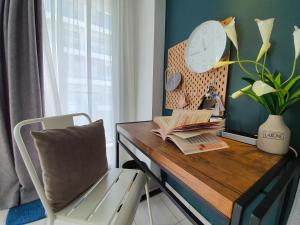 a desk with a chair and a clock and books at Aeropod Studio- Laxzone Suite in Kota Kinabalu