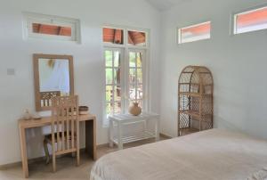 - une chambre avec un lit, un bureau et des fenêtres dans l'établissement Golden Beach Paradise, à Tangalle