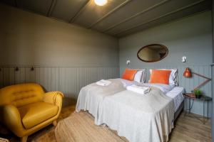 um quarto com 2 camas e uma cadeira amarela em Riverfront Lodge Hella em Hella