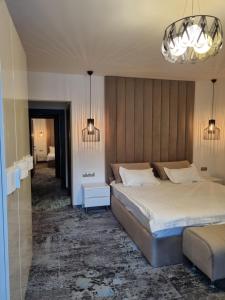 a bedroom with two beds and a chandelier at Pensiunea Ellemar in Vatra Dornei