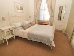 a bedroom with a white bed and a window at Oakwood in Alnwick