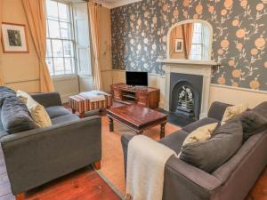 a living room with two couches and a fireplace at Oakwood in Alnwick