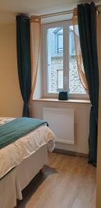 a bedroom with a bed and a window at Port de La Houle - Beau 2 pièces classé 3 étoiles avec stationnement in Cancale