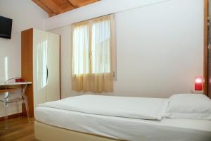a white bedroom with a bed and a window at Via Verdi B&B in Vago