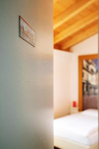 two pictures of a bedroom with a sign on the wall at Via Verdi B&B in Vago