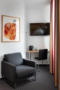 a living room with a couch and a table and a desk at Tiemanns Boardinghouse in Lemförde