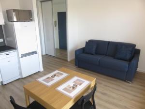 - un salon avec un canapé bleu et une table dans l'établissement ANGLET-BIARRITZ Studio vue Mer - Terrasse + Garage, à Anglet