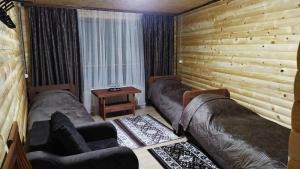 アルヒズにあるBaza otdykha Rechnoy Breezのベッド2台、ソファ、テーブルが備わる客室です。