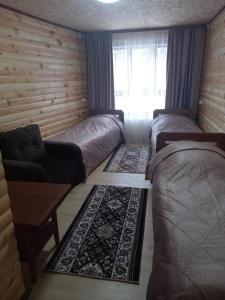 アルヒズにあるBaza otdykha Rechnoy Breezのベッド2台、ソファ、窓が備わる客室です。