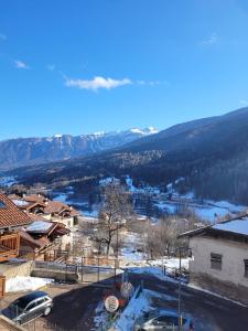 uma vista para uma cidade na neve com montanhas em Casa Luca em Mezzana