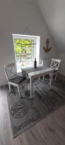 una sala da pranzo con tavolo, panca e finestra di Haus Groth - Wohnung Heinke - Schupp1 a Tönning