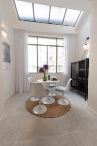 ein weißes Wohnzimmer mit einem Tisch und Stühlen in der Unterkunft Mayenne in Paris