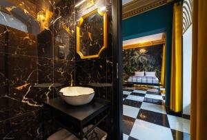 a bathroom with a sink and a black tiled floor at Jungle Apartments in Wrocław