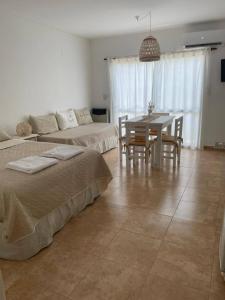 a living room with two beds and a dining table at Munich Apart cdelu in Concepción del Uruguay