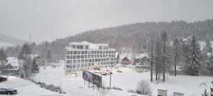 duży budynek w śniegu w mieście w obiekcie Apartament Złota Perła Czarna Góra w mieście Sienna
