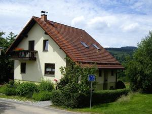 a small white house with a red roof at Ferienwohnung Am Stachelsrain in Zella-Mehlis