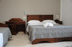 a bedroom with two beds with white towels on them at Hotel Sannita in Casoria