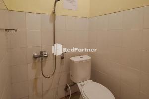 een badkamer met een toilet en een douche bij Batu Homestay Puncak Mitra RedDoorz in Pasirmuncang 1