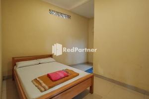 een slaapkamer met een bed in een kamer bij Batu Homestay Puncak Mitra RedDoorz in Pasirmuncang 1