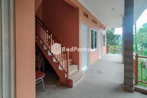 een kamer met een trap in een huis bij Batu Homestay Puncak Mitra RedDoorz in Pasirmuncang 1
