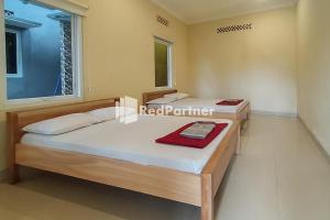 Ένα ή περισσότερα κρεβάτια σε δωμάτιο στο Batu Homestay Puncak Mitra RedDoorz