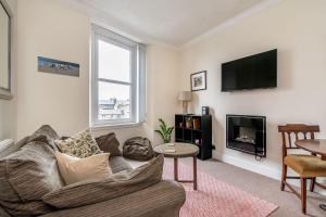 a living room with a couch and a tv at amazing apartments - Torphichen Place by Haymarket in Edinburgh