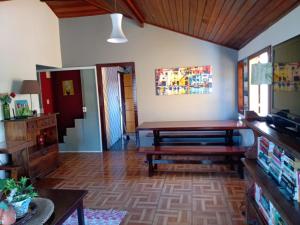 sala de estar con mesa y banco en Casa de Temporada Centro Búzios, en Búzios