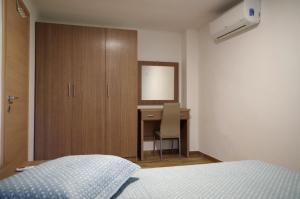 a bedroom with a bed and a desk with a mirror at Anesis Luxury Apartments in Skala Sotiros