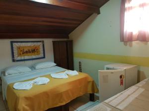 1 dormitorio con 2 camas y toallas. en Peruíbe Suíte Flat Hotel, en Peruíbe