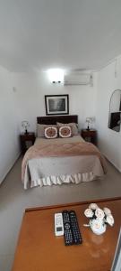 a bedroom with a bed with two remote controls on a table at Apartamento Familiar Marta in Colonia del Sacramento