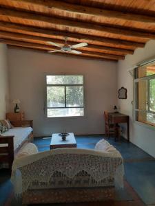 a living room with a couch and a ceiling fan at La Roja y Barro tal vez in Los Molles