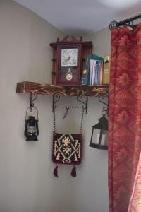 a shelf with a clock and lights on a wall at HANI I VJETER Boutique Hotel in Prizren
