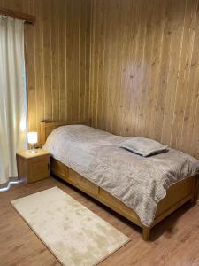 um quarto com uma cama e uma parede de madeira em Villa Tama Pirin Golf and Spa em Bansko