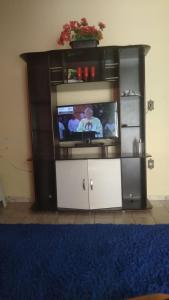 un centro de entretenimiento con TV en la sala de estar en Santo Ivo 3, en Aparecida