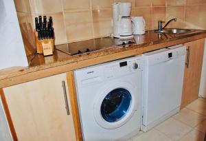 una cucina con lavatrice sotto un bancone di Charming duplex in the heart of the village - Charmant duplex au coeur du village - a Saint-Tropez