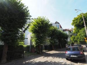 een auto geparkeerd aan de kant van een straat met bomen bij Family Suite Parking 2 Bathrooms 300 m sea in Sopot