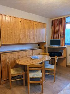 - une salle à manger avec une table et des chaises en bois dans l'établissement Studio Gil La Bresse Hohneck, à La Bresse