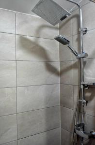 y baño con ducha con cabezal de ducha. en HANI I VJETER Boutique Hotel, en Prizren