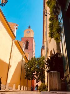 Un edificio con una torre dell'orologio in mezzo a una strada di Charming duplex in the heart of the village - Charmant duplex au coeur du village - a Saint-Tropez Altre 4 foto