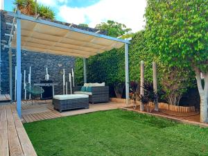 a backyard with a wooden deck with a pergola at Duplex with sea views, garden and terrace in Santa Cruz de Tenerife